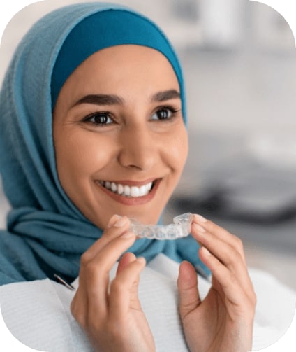 Smiling woman placing Invisalign orthodontics tray